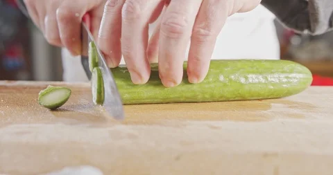 Slow motion close up of a chef knife slicing a cucumber Stock Footage 125526135