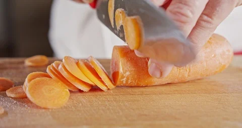 Slow motion close up of a chef knife slicing a carrot Stock Footage 125528495