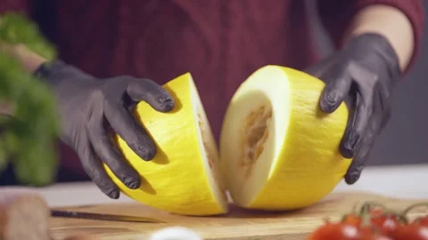 Slow Motion Close-Up of Chef Splitting Fresh Yellow Melon in Half Stock Footage 302782584