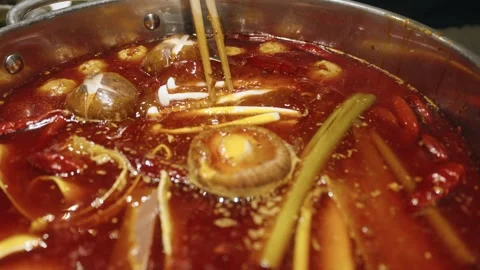 Slow Motion Close-up: Chopsticks Placing Enoki Mushrooms into Spicy Hot Pot Stock Footage 342441953