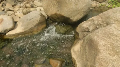 Slow motion close up of a clear rocky river cascade Stock Footage 323043310