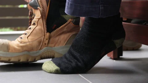 Slow motion close up of construction worker putting on their work boots  Stock Footage 239968907