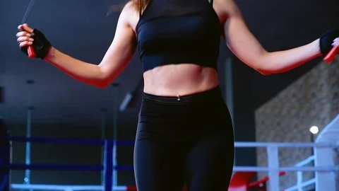 Slow motion close-up cute slim brunette woman jumps on rope training in gym Video stock 93259712