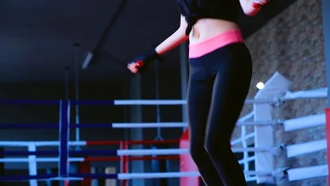 Slow motion close-up cute slim brunette woman jumps on rope training in gym 動画素材 93260035