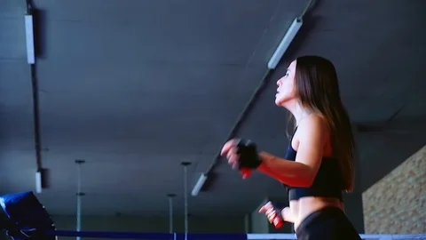 Slow motion close-up cute slim brunette woman jumps on rope training in gym 動画素材 94131231
