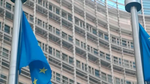 Slow motion close-up of dancing EU flags in front of EU Comission in Brussels Vidéo 93414354