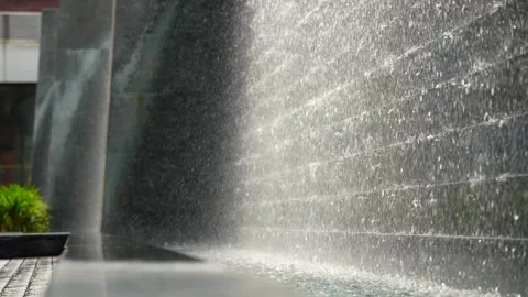 Slow motion close up of decorative cascade waterfall stone wall on the city Stock Footage 289180191