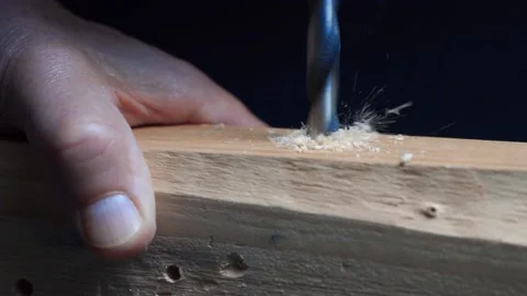 Slow motion close up of drill bit drilling into wood. Wood chippings fly off. Stock Footage 219236375