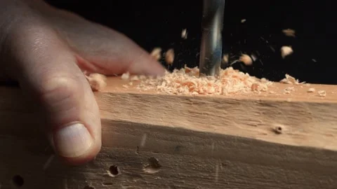 Slow motion close up of drill bit drilling into wood. Chippings fly off. Stock Footage 219236376