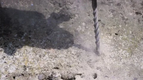 Slow motion close up of drill bit drilling through concrete Stock Footage 275297748