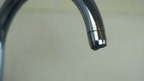 SLOW MOTION: close-up a droplets of water slowly drip from the tap. Video stock 82785207