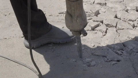 Slow motion close-up of an electric jackhammer breaking concrete pavement Stock Footage 343397220
