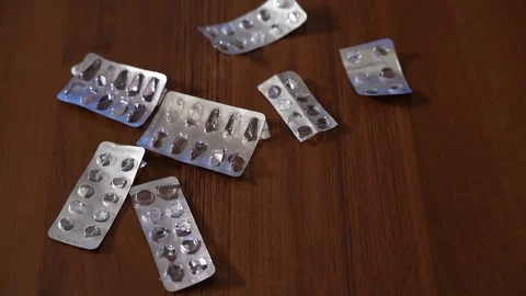Slow motion Close up of empty blister pack of pills being thrown onto table Stock-Footage 130187748