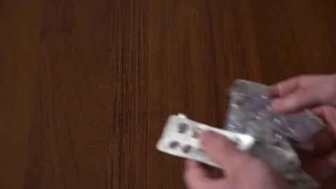 Slow motion Close up of empty blister pack of pills being thrown onto table Stock Footage 130188388