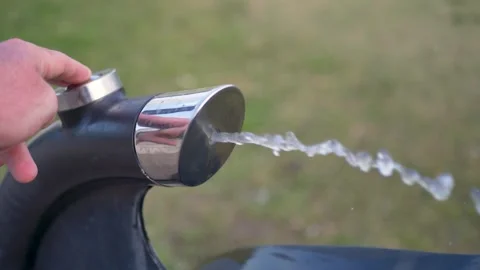 Slow motion close-up of a finger pressing a push-button for a water fountain Stock Footage 346623568