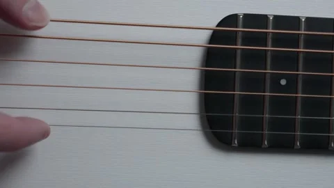 Slow Motion Close Up of Fingers Plucking Two Acoustic Guitar Strings Stock Footage 330119720