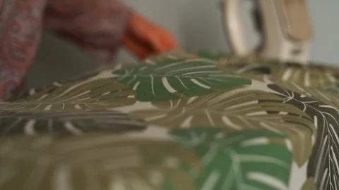 Slow Motion Close up on Floral Pattern Cloth Placed on Wobbly Ironing Board Stock Footage 106012996