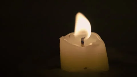 Slow-motion close-up footage of a small candle burning in the dark 動画素材 251668376