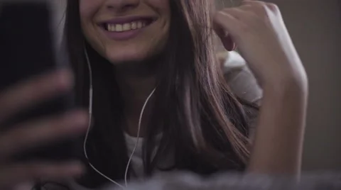 Slow motion close-up footage of young female lies in a bed and uses smartphone Stock Footage 61336823