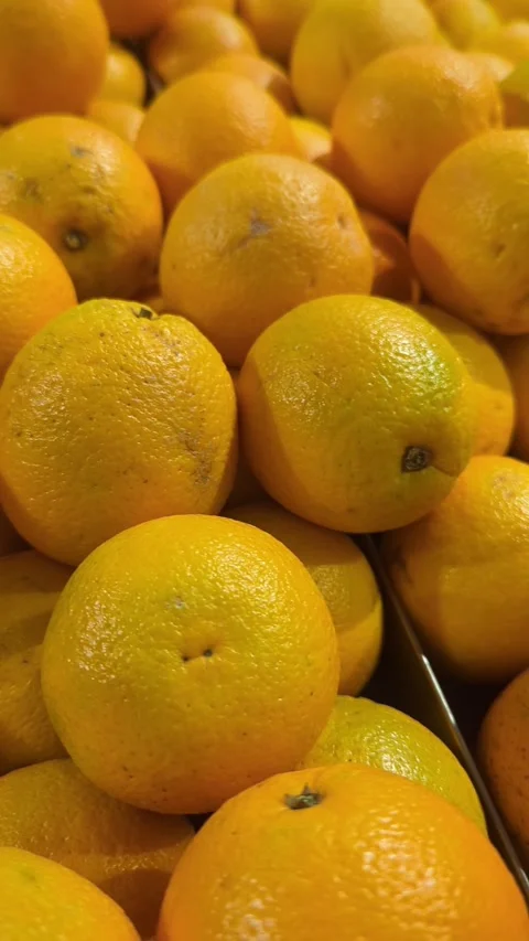 Slow motion close-up of fresh organic oranges stacked at a local market stall. Stock Footage 328714095