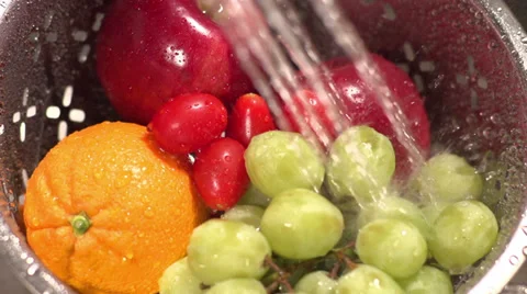 Slow motion close up of fruit being washed by water in a colander. Vídeo Stock 34655084