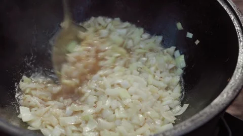 Slow motion close-up of frying chopped onions in rendered fat inside cauldr.. Stock Footage 319660694