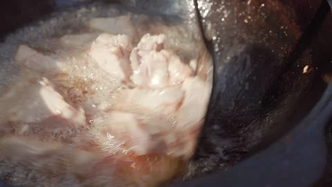 Slow motion close-up of frying lamb meat in rendered fat inside cauldron du.. Stock Footage 319661001
