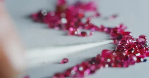 Slow motion close up of goldsmith sorting high quality fuxia diamonds. Video stock 114942662