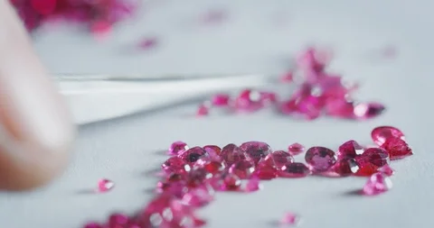 Slow motion close up of goldsmith sorting high quality fuxia diamonds. Video stock 114942755