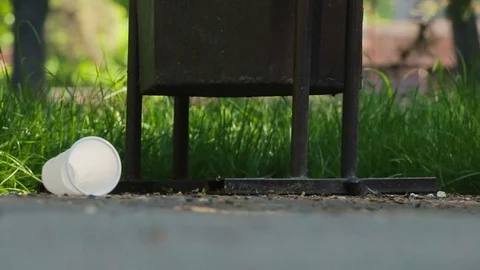 Slow motion close up of a hand picking up a plastic cup near the waste bin Stock Footage 75999320