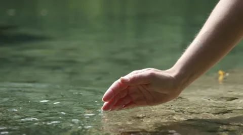 SLOW MOTION CLOSE UP: Hand playing with clear fresh water Stock Footage 55728788