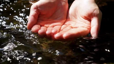 SLOW MOTION CLOSE UP Hand playing with clear fresh water in beautiful mountai Stock Footage 270407090