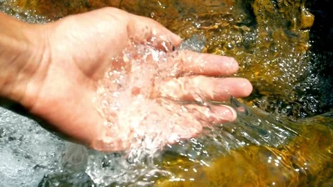 SLOW MOTION CLOSE UP Hand playing with clear fresh water in beautiful mountai Stock Footage 270407305