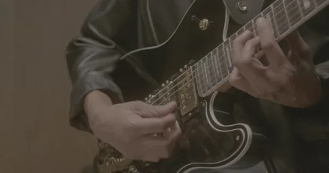 Slow Motion Close-Up of Hand Strumming Electric Guitar Stock-Footage 323975047
