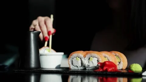 Slow motion close up of hand using chopsticks to eat sushi in dark restaura.. Stock Footage 346622519