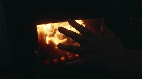 Slow Motion Close-Up of a Hand Warming by a Burning Wood Stove Fire Stock Footage 342243233