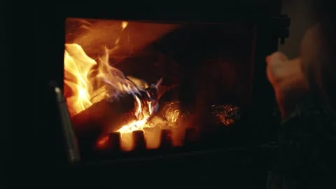 Slow Motion Close-Up of a Hand Warming by a Wood-Burning Stove Fire Stock Footage 342265856