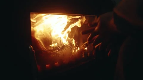 Slow Motion Close-Up of a Hand Warming by a Burning Wood Stove Stock Footage 342585659