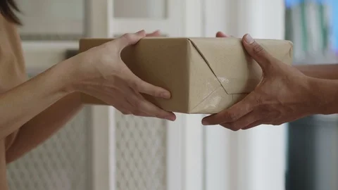 Slow Motion: Close up hands Asian woman receive a cardboard box from a man's Stock Footage 113398589