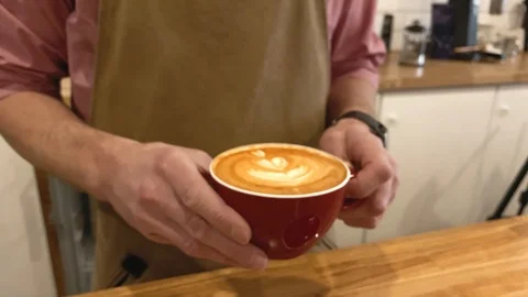 Slow motion. Close up hands of barista holding red cup coffee. Smart watch  Video stock 123552490