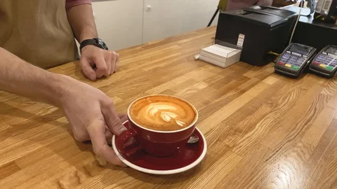 Slow motion. Close up hands of barista giving red cup coffee to client. Wood Stock Footage 123552510