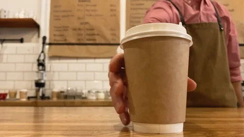 Slow motion. Close up hands of barista. Barista puts a paper cup on the wood Stock Footage 123552609