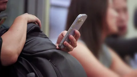 Slow motion close-up of hands holding smartphone while traveling on metro train Stock Footage 321144350