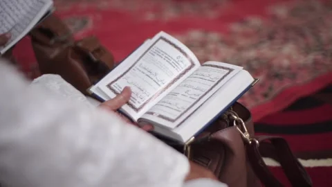 Slow Motion Close-up of Hands Holding and Opening the Holy Quran Stock Footage 341107900