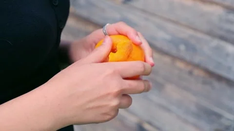 Slow Motion Close-Up of Hands Peeling a Fresh Tangerine Stock Footage 320840152