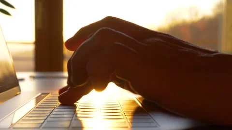 SLOW MOTION, CLOSE UP: Hands typing on laptop keyboard in early morning sunlight Stock Footage 191742545