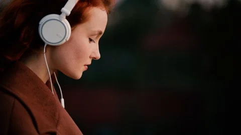 Slow motion close up of happy red hair girl enjoying music in the street Stock Footage 122078911