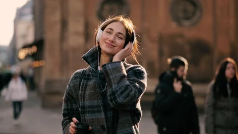 Slow motion close up of happy young woman enjoying music in the street. Portrait Stock Footage 121953657