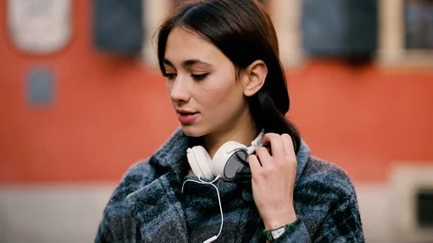 Slow motion close up of happy young woman with headphone looking into the camera Stock Footage 121953853