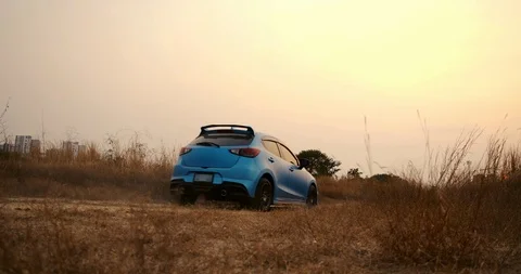 SLOW MOTION, Close up Hatchback car Driving on beautiful forest summer sunset Stock Footage 124582320